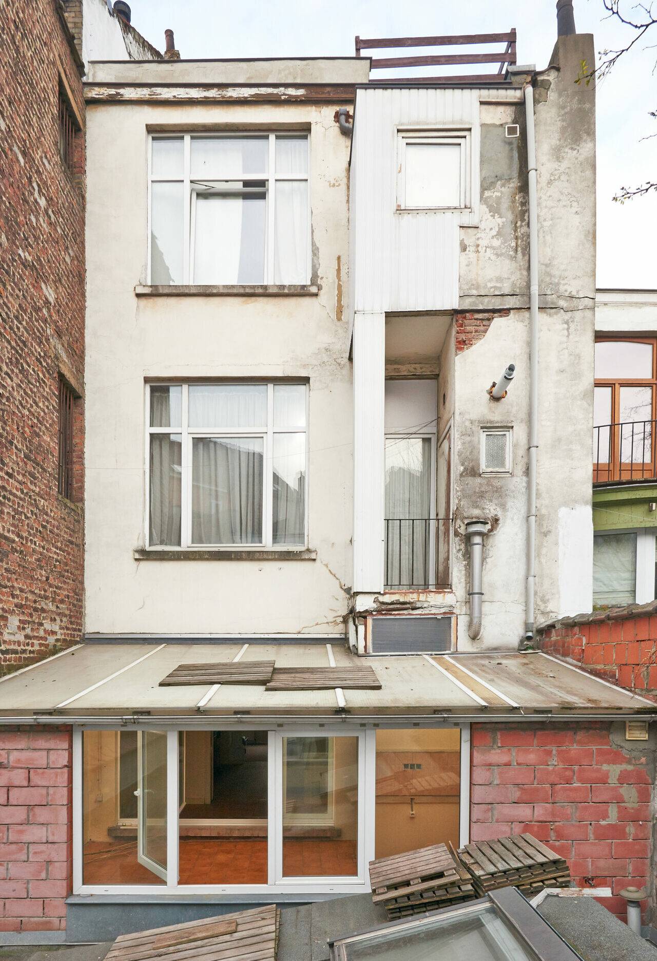 Construction of a new facade in courtyard  from old house before and after